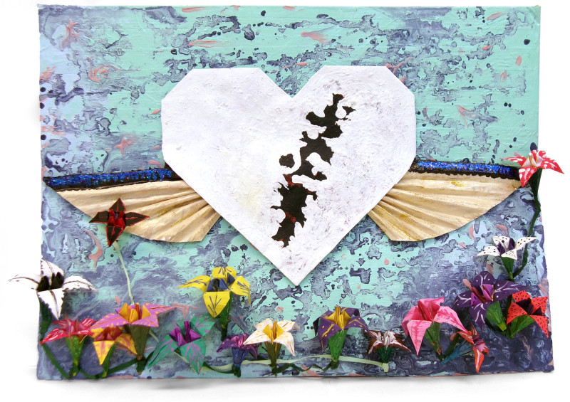 A low relief collage of a central heart with flowers below it. The flowers depart in three dimensions from the picture plane. They are made of folded paper, have brightly colored petals, and are on vines or stems. The central heart is white, with black splotches in its center and tan wings on either side. The background is an abstract pattern of seafoam and navy blue.