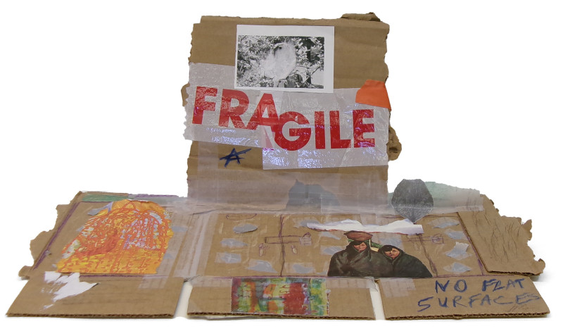 A sculptural collage made from a disassembled cardboard box. The word 